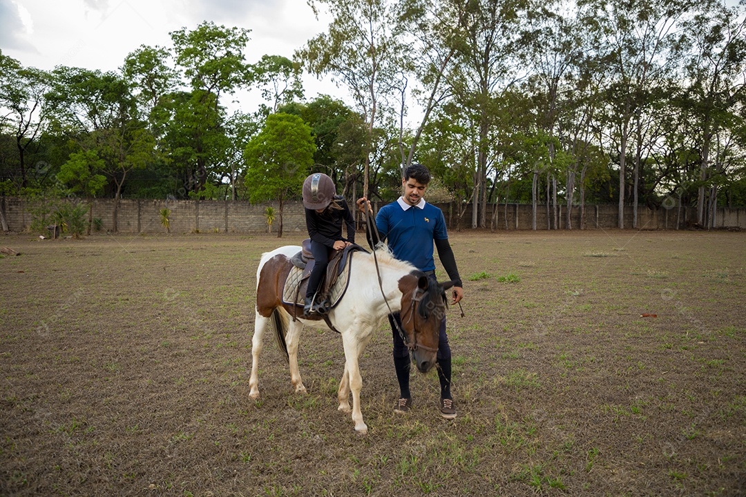 Linda garotinha praticando hipismo