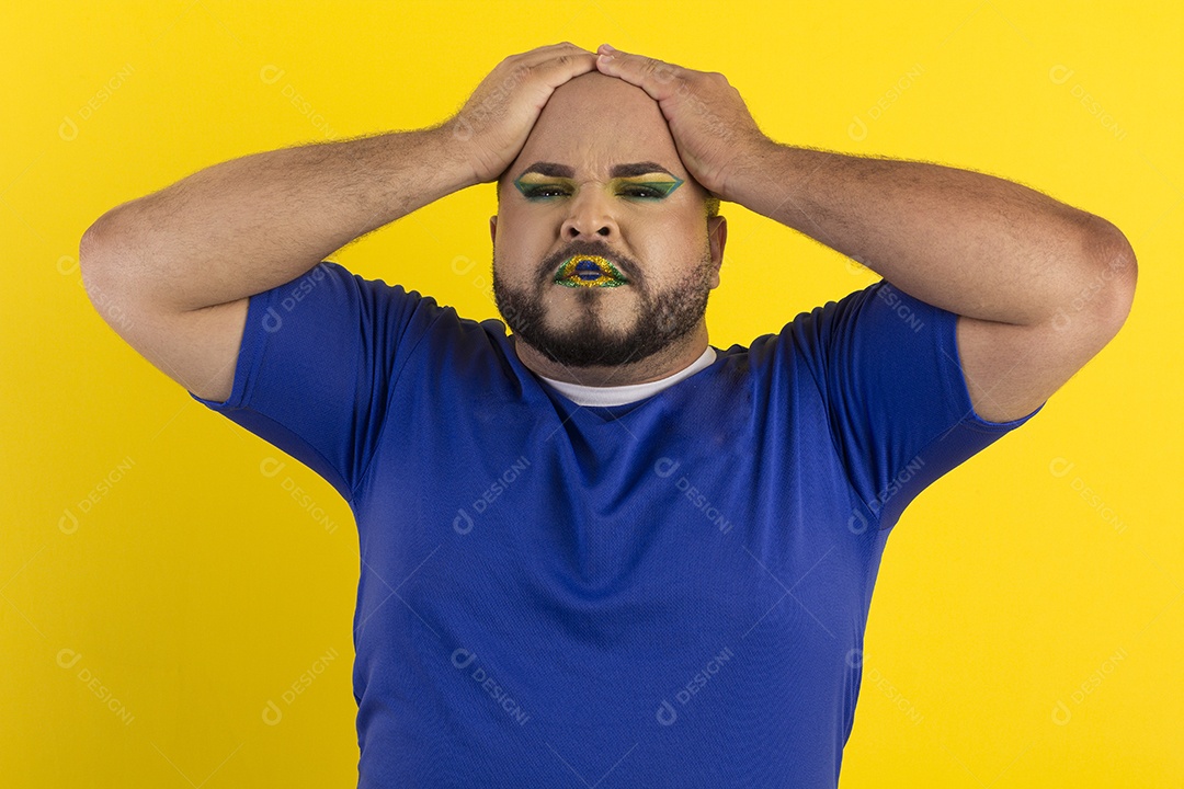 Um jovem maquiado com mãos na cabeça