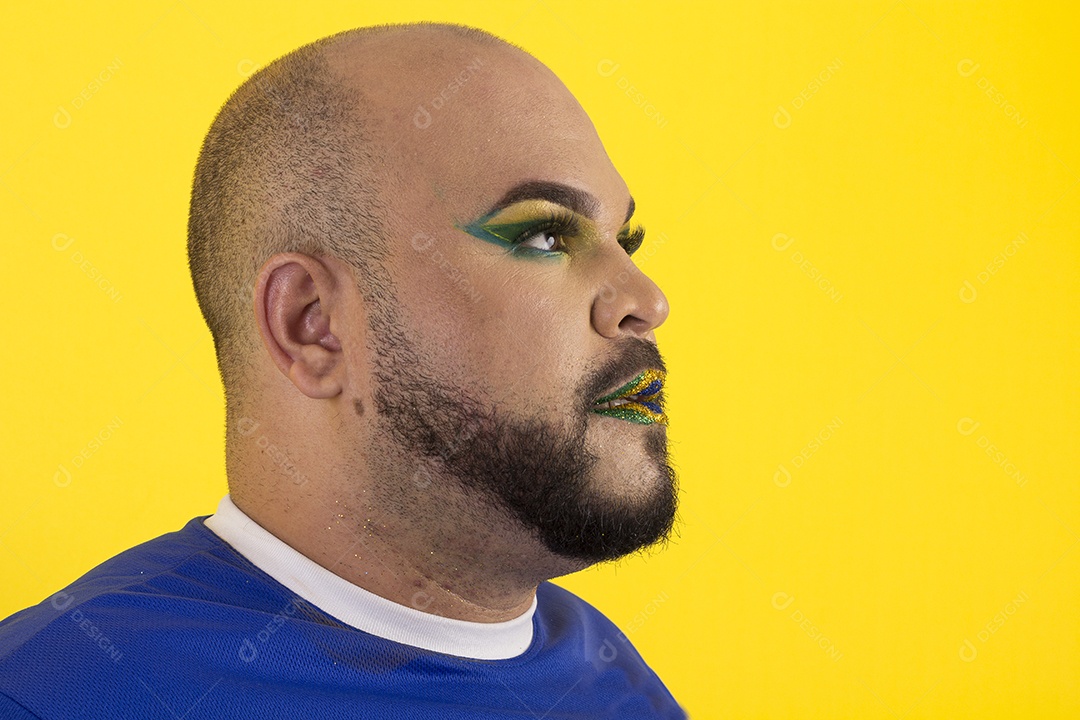 Um jovem com uma linda maquiagem de verde e amarelo