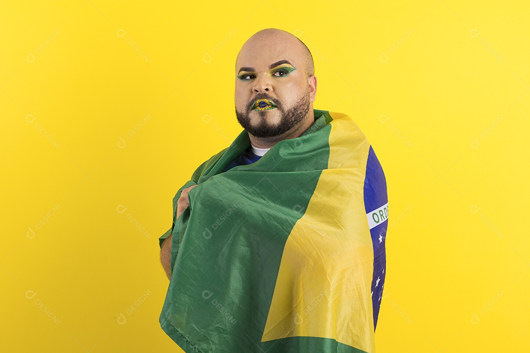 Jovem maquiado serio coberto com bandeira do brasil