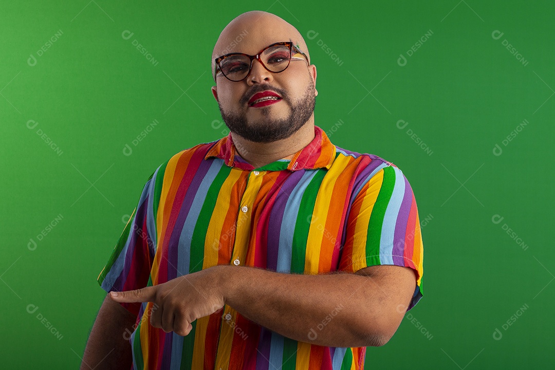 Jovem bonito gay com roupa colorida apontando o lado