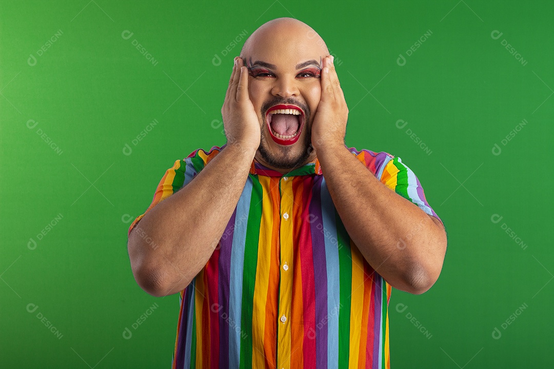 Jovem maquiado e usando camiseta colorida com gesto de surpreso e feliz