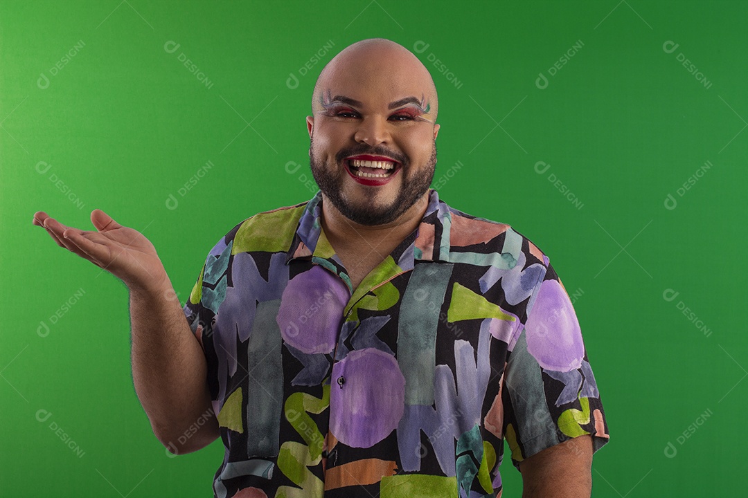 Um jovem gay feliz maquiado fazendo pose com mãos para o lado