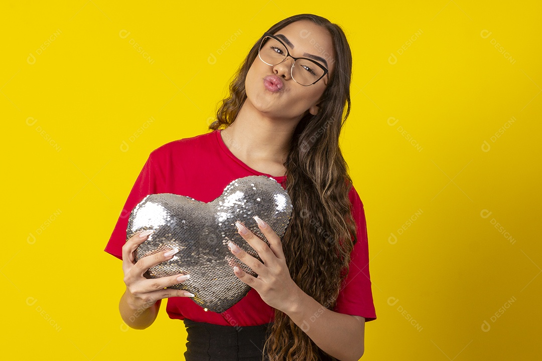 Garota fazendo bico segurando coração na mão