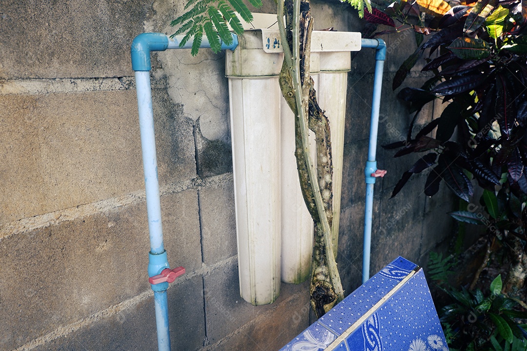 Um filtro de água de 20 polegadas está instalado próximo à parede da cerca