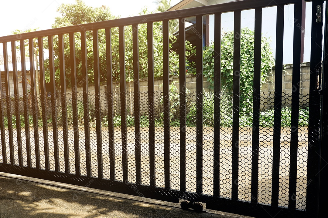 O portão frontal da casa é feito de aço soldado verticalmente