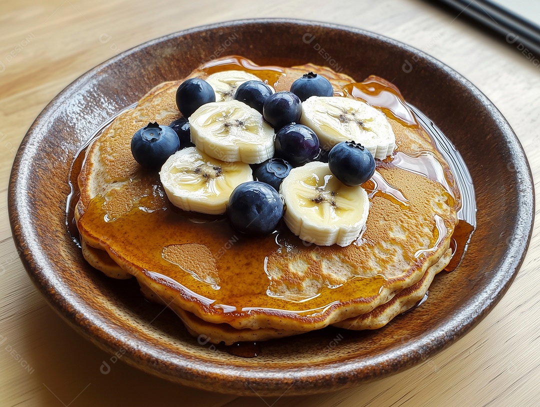 Delíciosa panqueca coberta por  mel mirtilo e banana sobre mesa de madeira