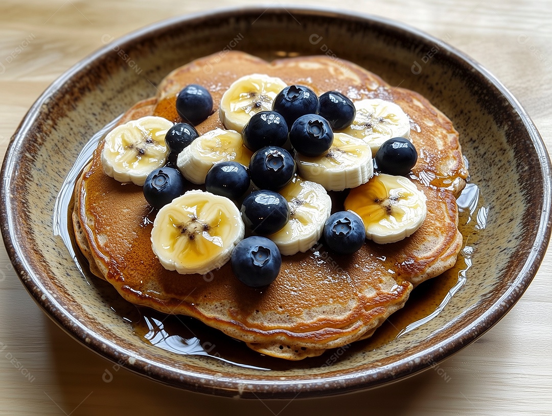 Delíciosa panqueca coberta por  mel mirtilo e banana sobre mesa de madeira