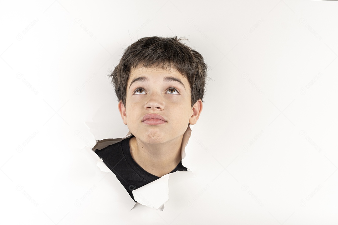 Criança com cabeça no buraco rasgado com careta olhando pra cima