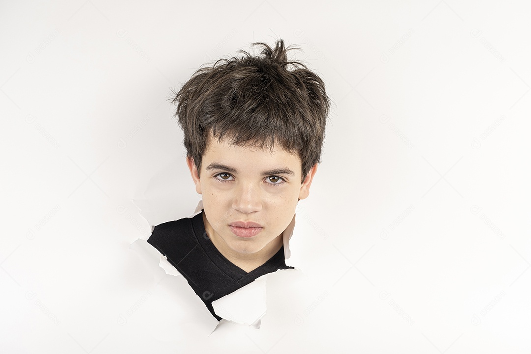 Menino com cabeça no buraco rasgado com cara de serio