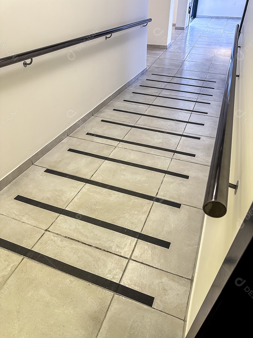 Piso do corredor com faixa antiderrapante e corrimão para segurança dos idosos