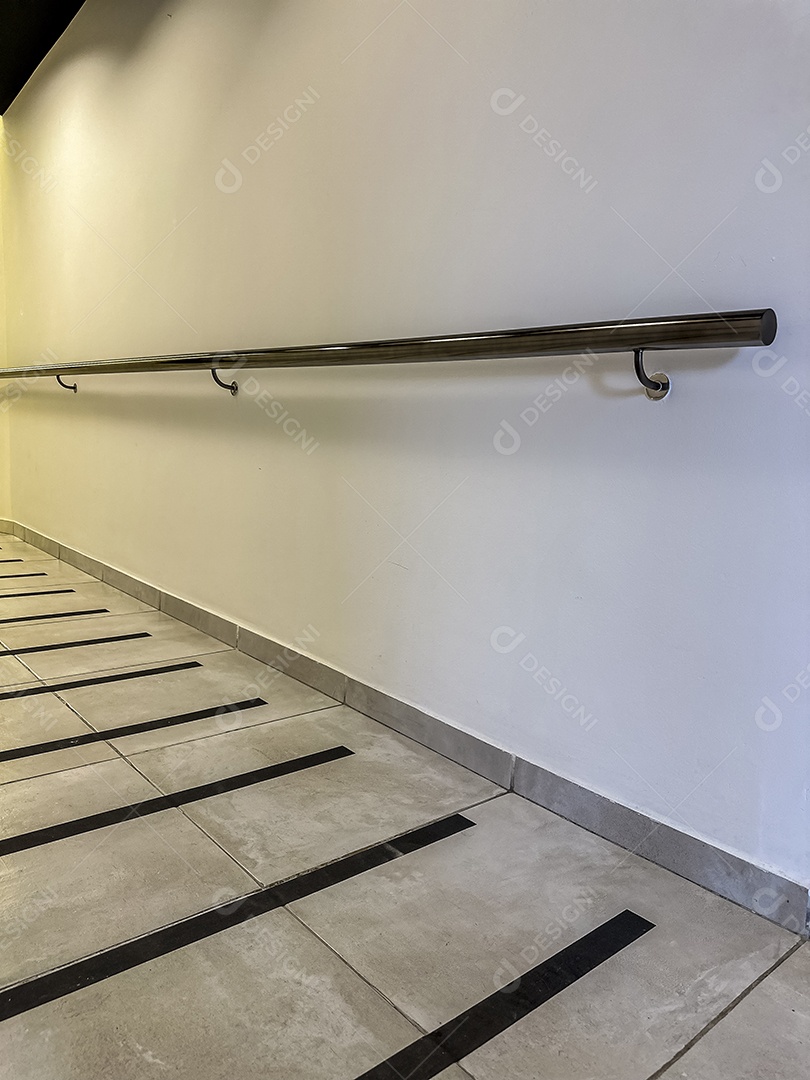 Piso do corredor com faixa antiderrapante e corrimão para segurança dos idosos