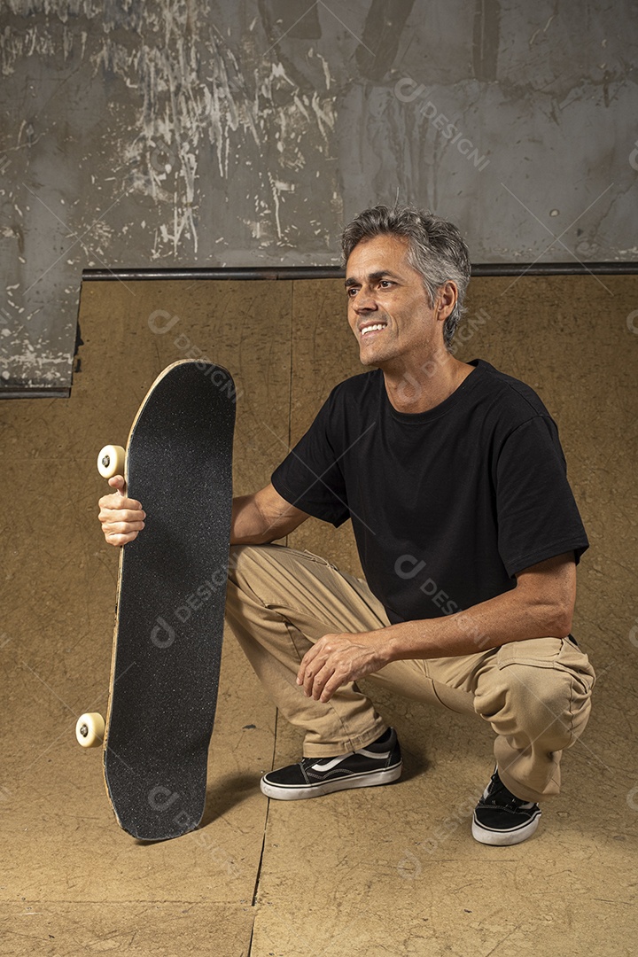 Homem de meia idade feliz com seu skate do lado