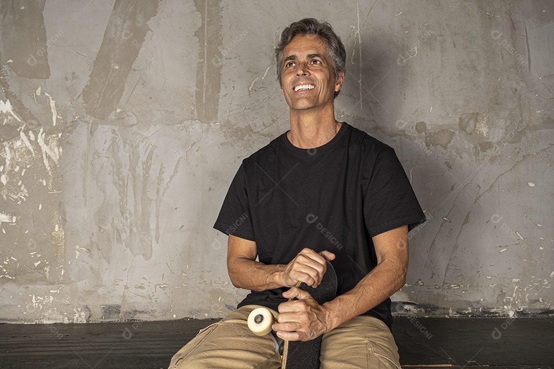 Homem charmoso com skate na mão