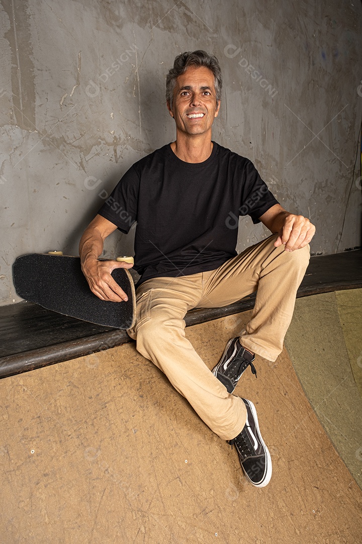 Homem de meia idade feliz com seu skate do lado