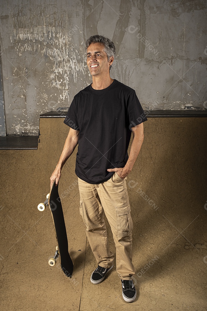 Homem charmoso com pose e um skate nas mão