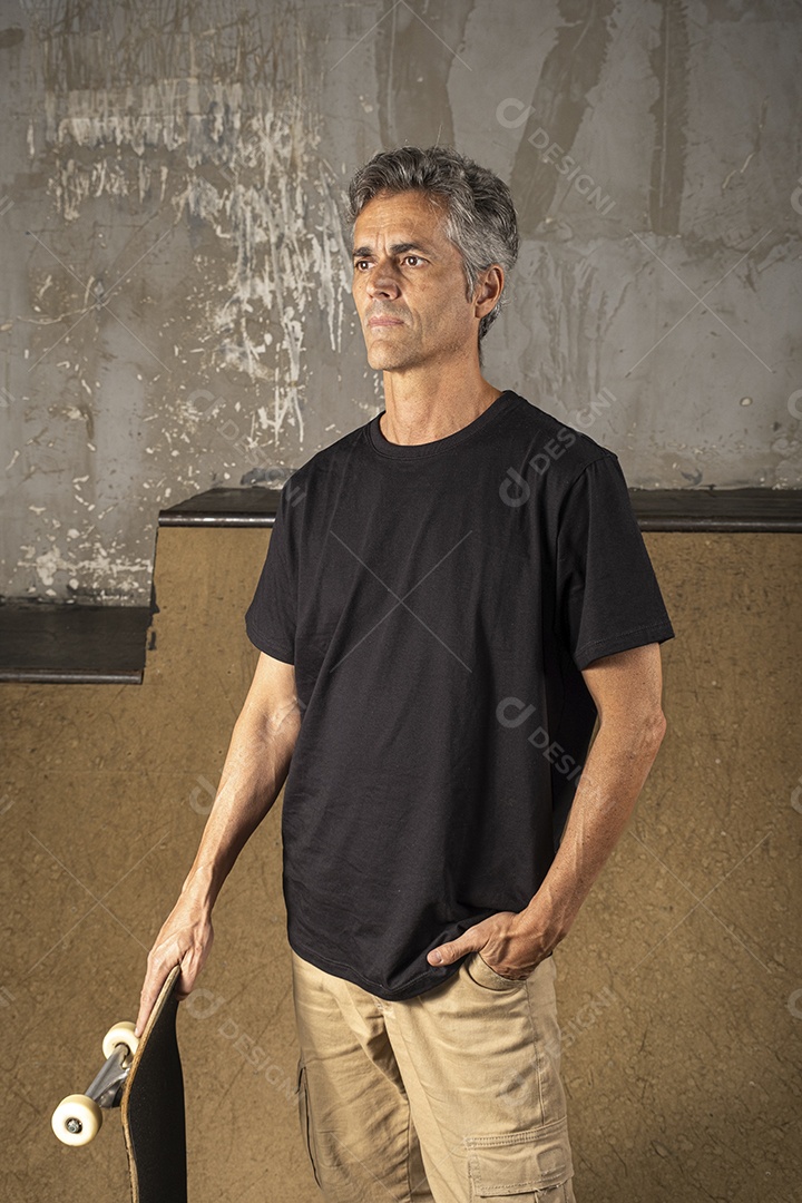 Homem com pose e skate nas mãos