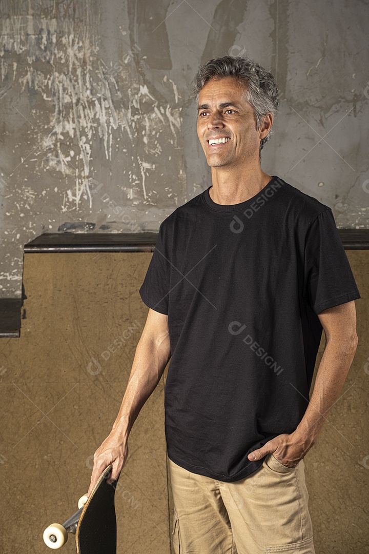 Homem com pose e skate nas mãos