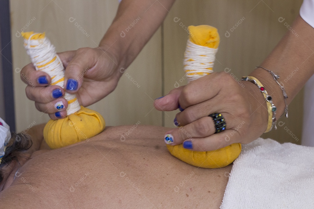 Mulher recebendo massagem de pindas chinesas nas costas