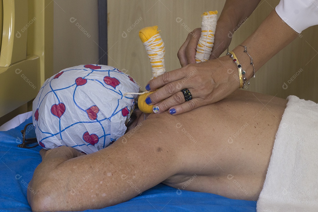 Mulher recebendo massagem de pindas chinesas nas costas