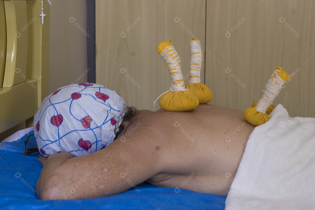 Mulher recebendo massagem de pindas chinesas nas costas