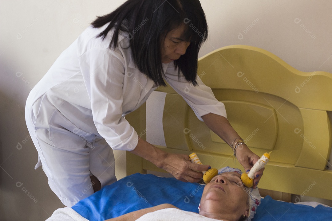 Woman receiving massage from Chinese facial pindas