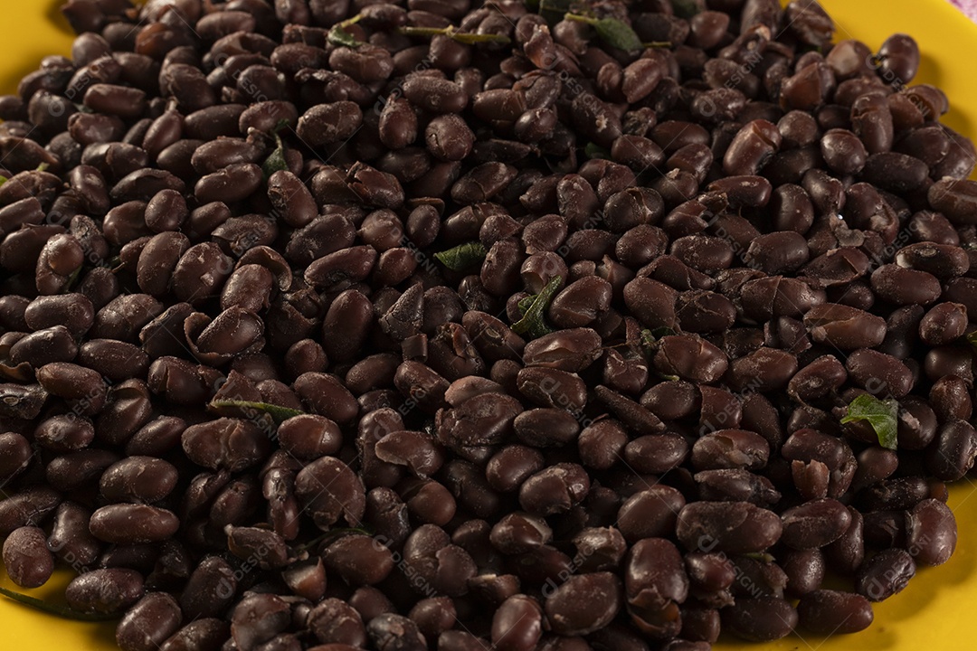 Grãos de feijão preto em uma vasilha amarela