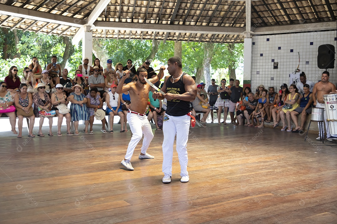 Homens capoeiristas em roda luta