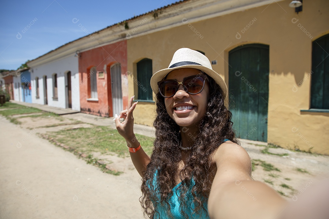 Jovem feliz em passeio enfrente aos casarões