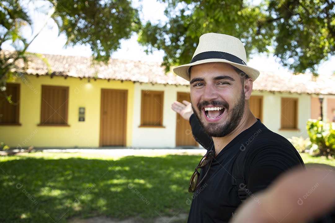 Jovem homem mostrando casarões no turismo