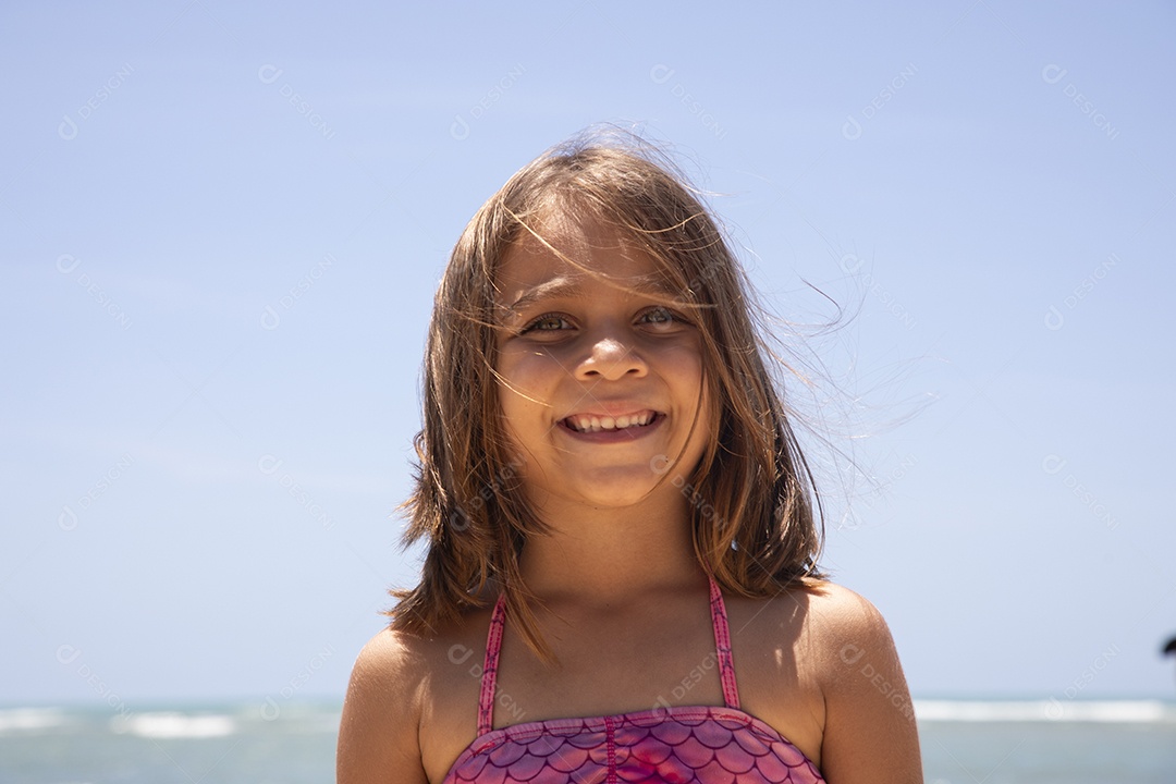 Uma adorável menina feliz na praia