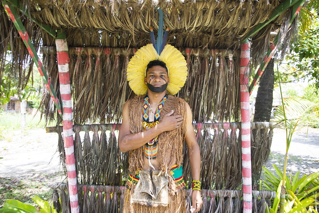 Um homem indígena com trajes da aldeia