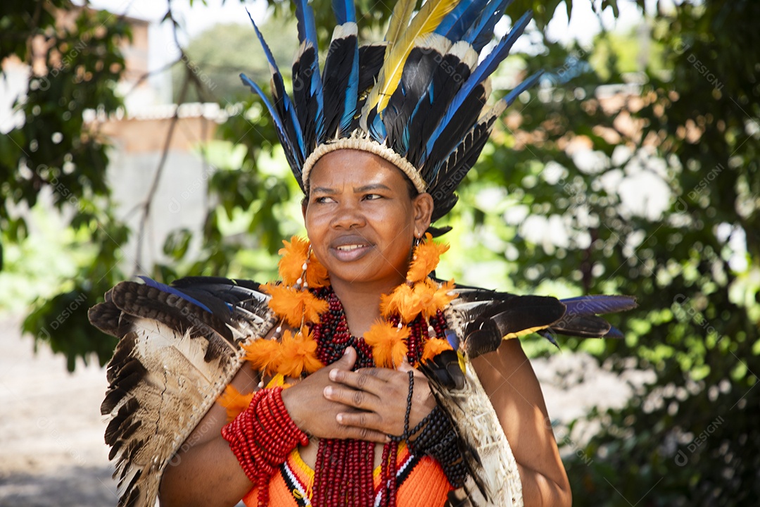 Uma mulher indígena bem seria com mãos no coração