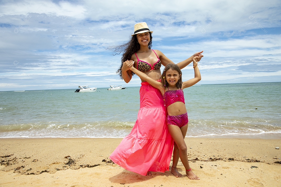 Uma mãe linda com sua filha na praia