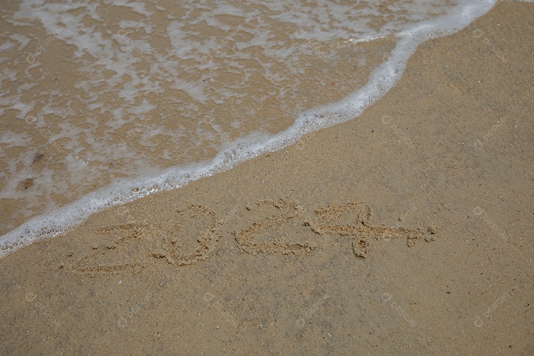 Praia com números na areia e ondas