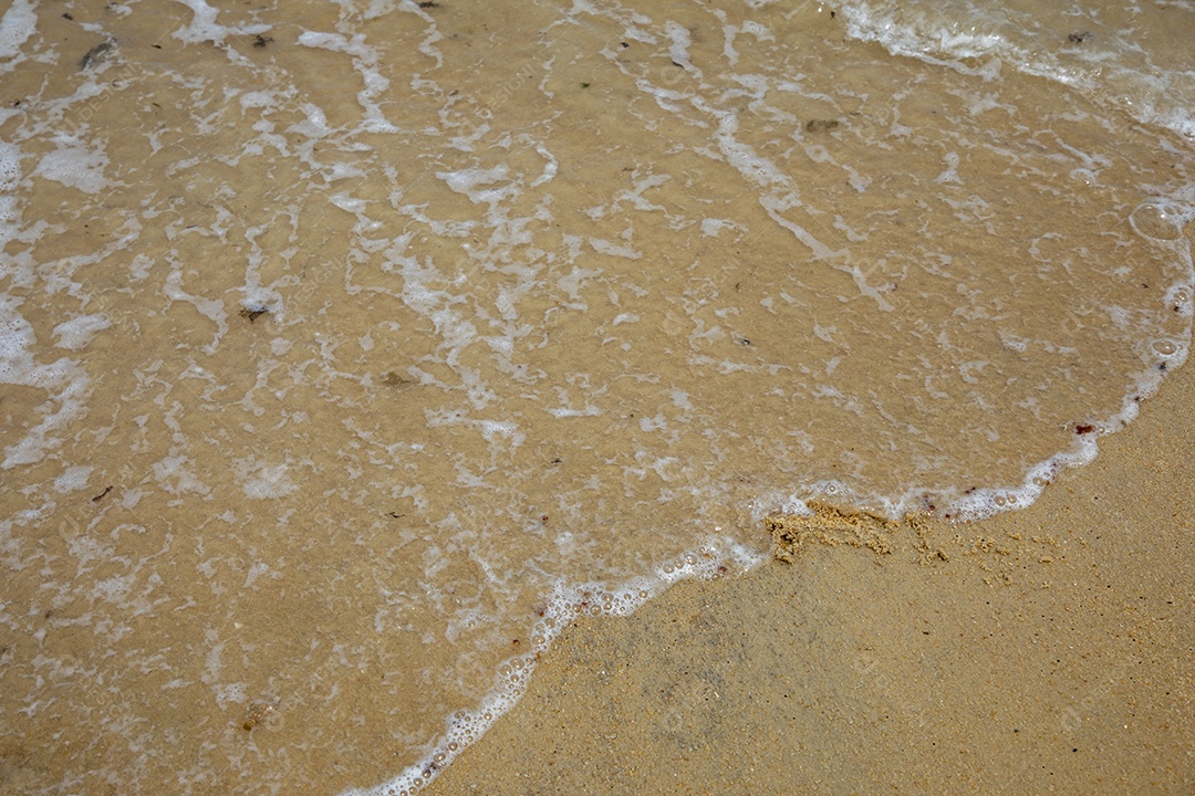 Areia da praia com ressaca do mar