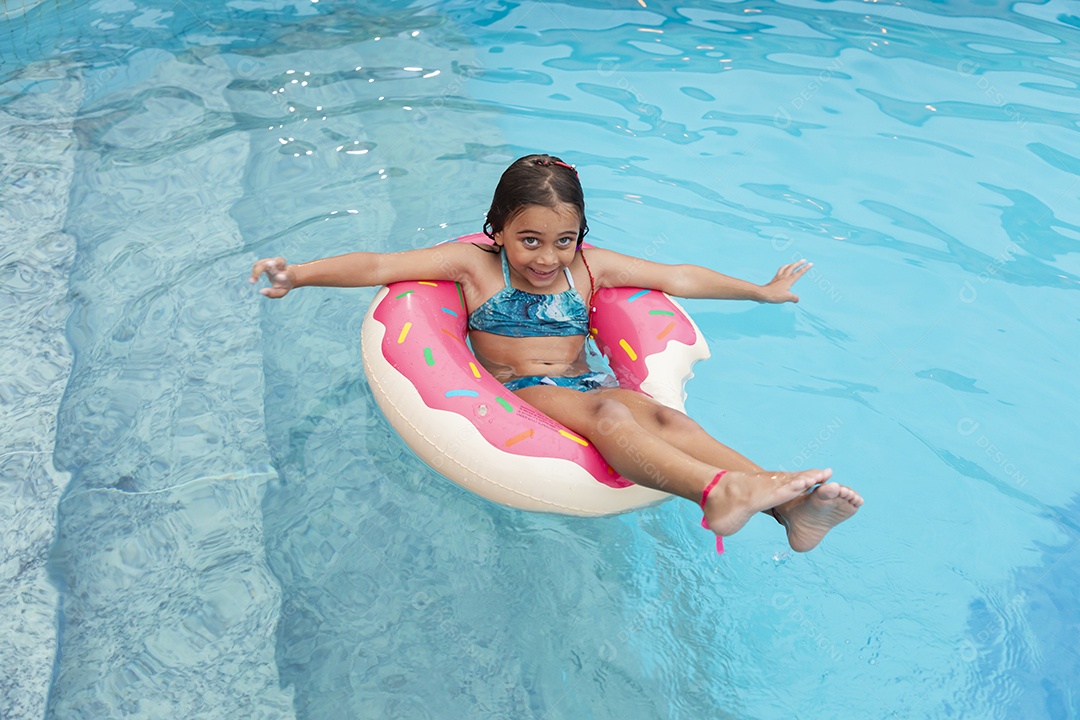 Garota feliz com boia banhando na piscina