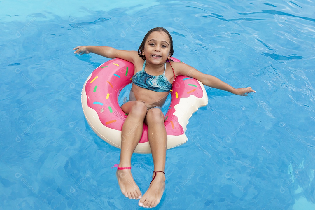 Menina fofa banhando em piscina com boia