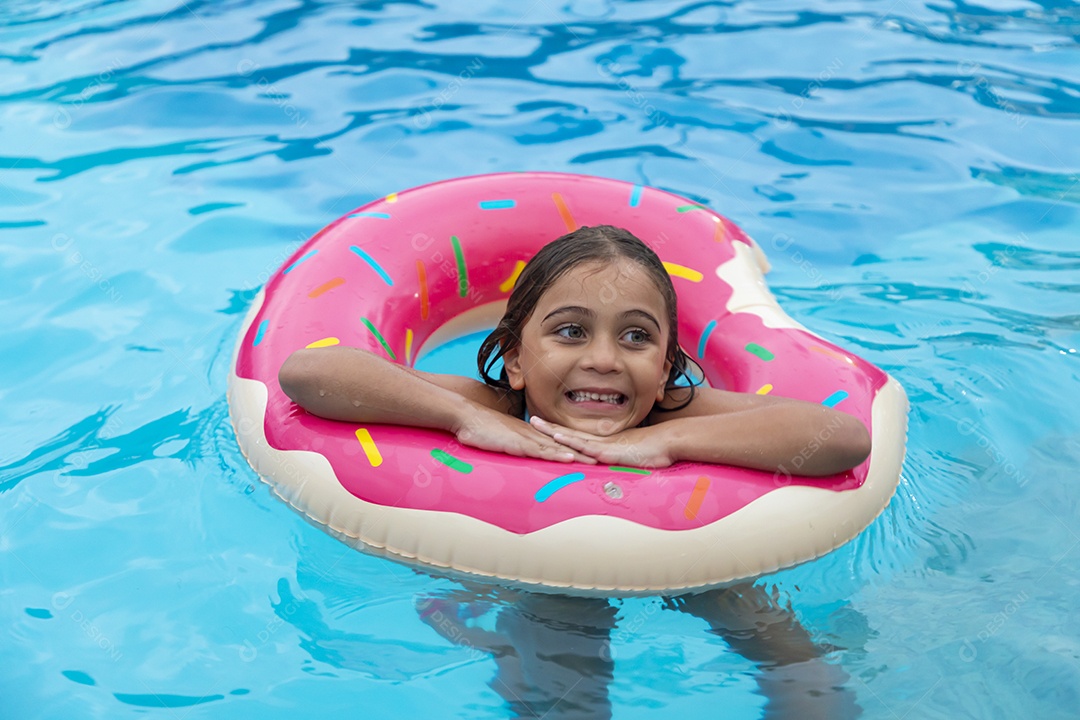 Linda garotinha com boia banhando na piscina