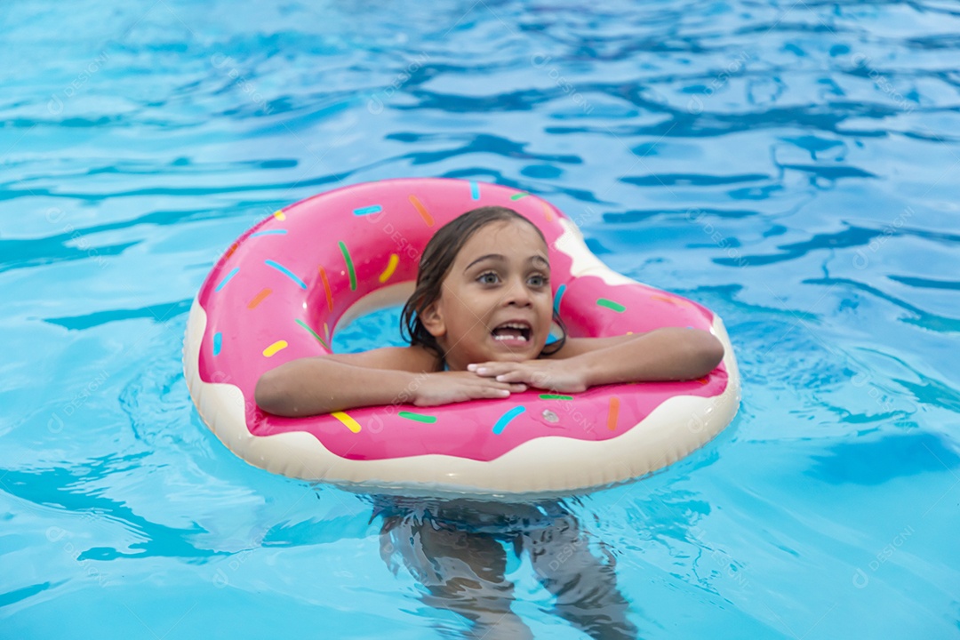 Uma linda menina banhando na piscina com boia