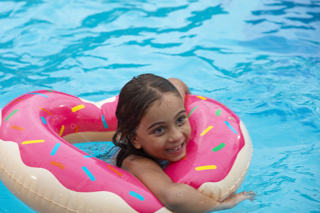 Uma linda menina feliz se divertindo na piscina