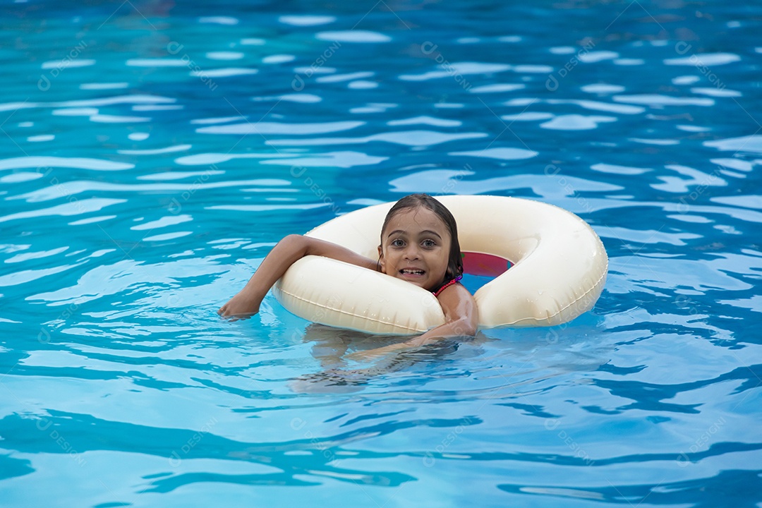 Menina fofa banhando na piscina com boia