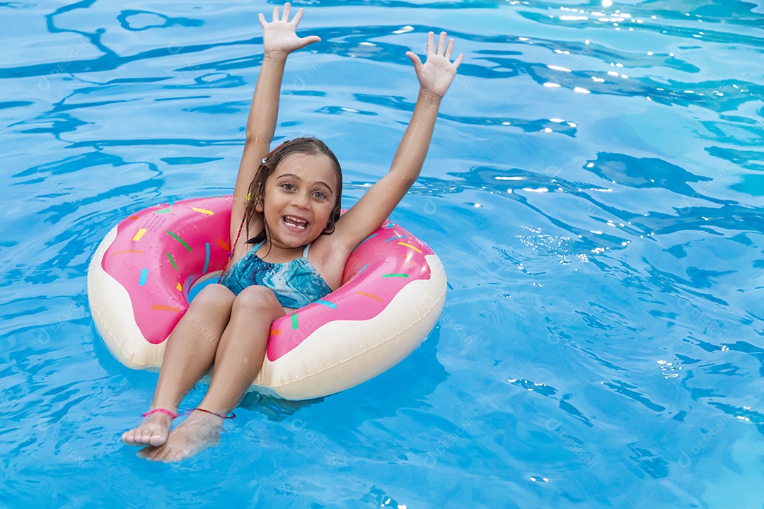 Menina feliz banhando com boia em piscina