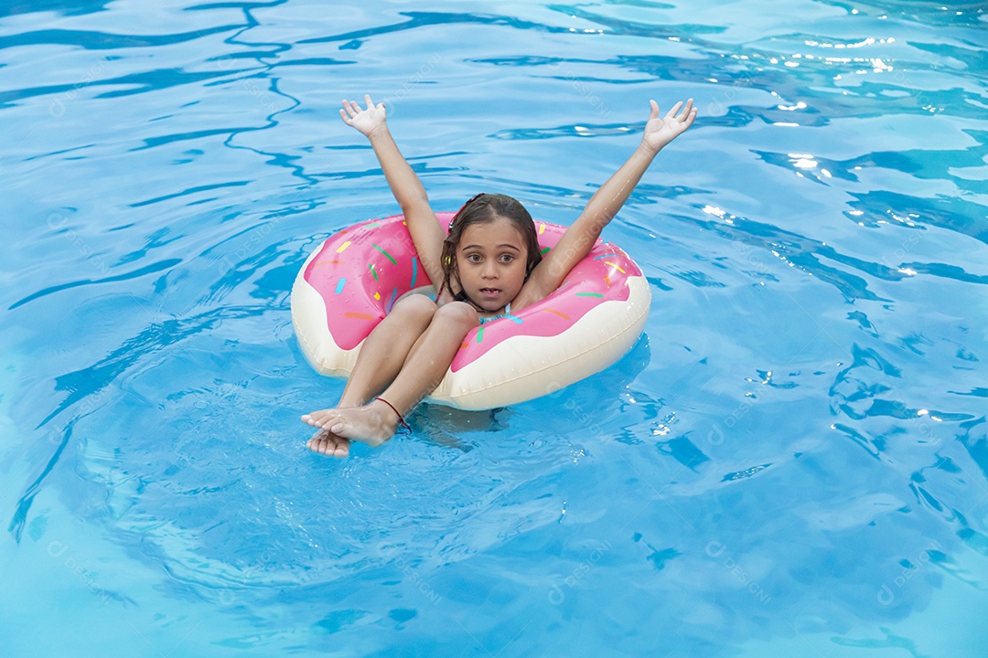 Uma garotinha fofa banhando na piscina com boia