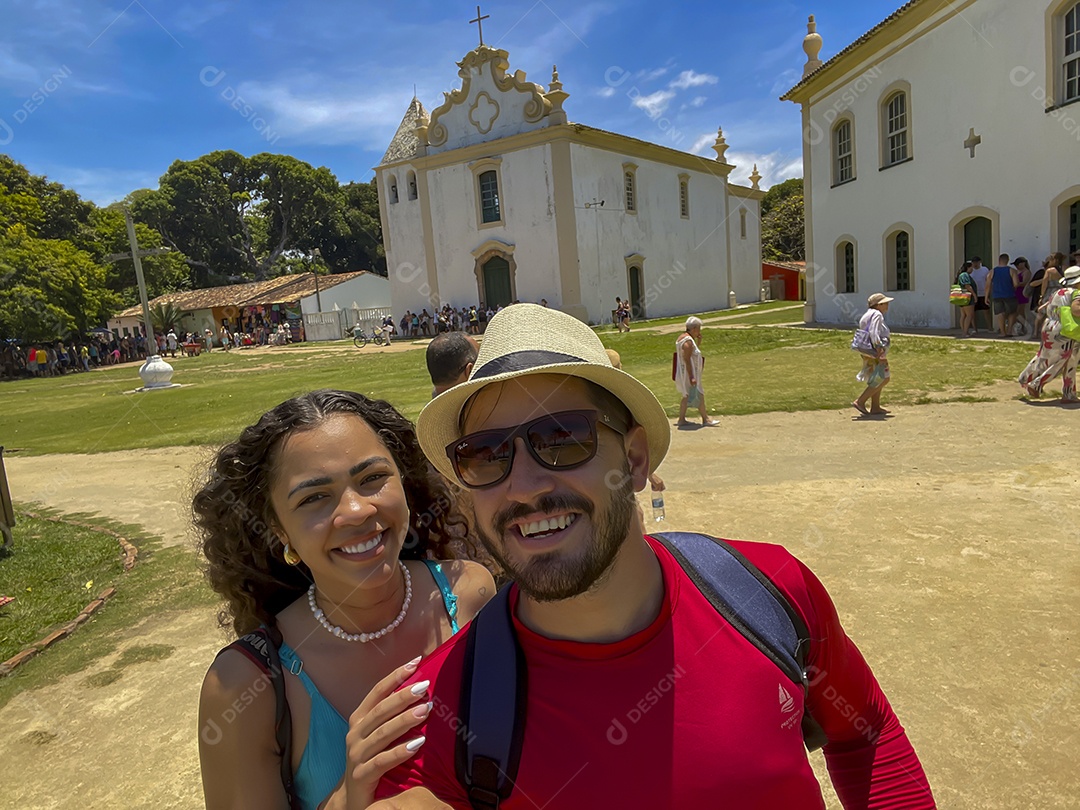 Lindo casal em passeio mostrando igreja