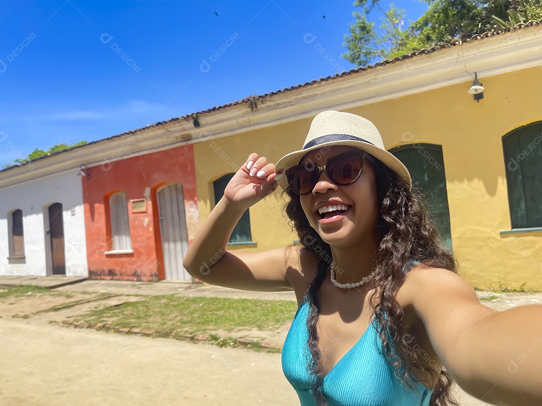 Jovem mulher feliz com mãos no chapéu