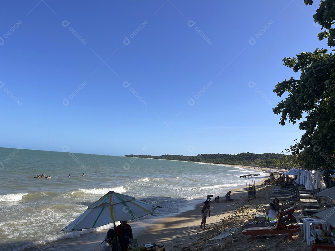 Praia sombra e muitas pessoas se divertindo