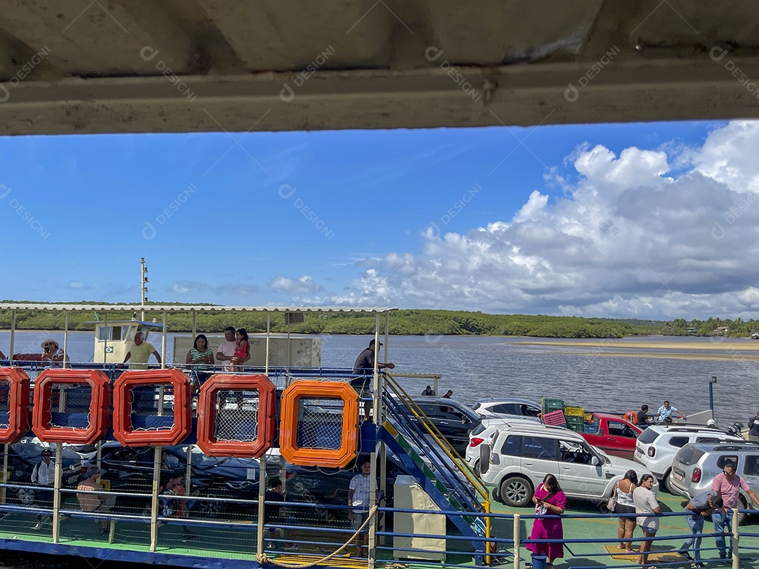 Balsa cheia de carros e pessoa atravessando o rio