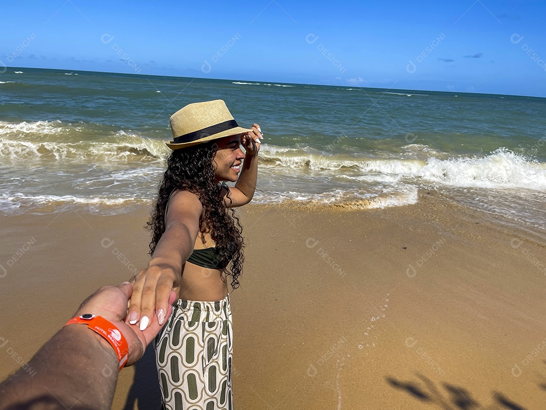 Uma linda mulher na praia olhando para o horizonte