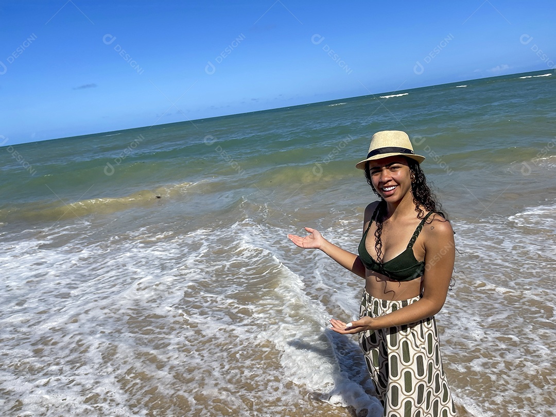 Jovem feliz na praia usando chapéu